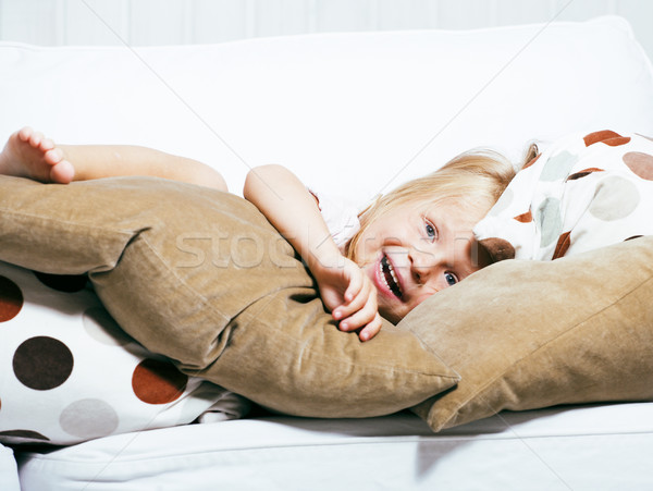 little cute blonde norwegian girl playing at home with pillows Stock photo © iordani