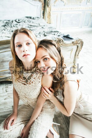 two pretty twin sister blond curly hairstyle girl in luxury house interior together, rich young peop Stock photo © iordani