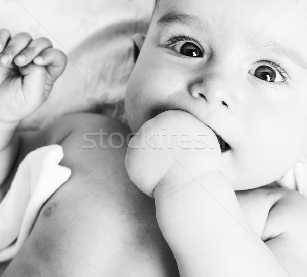 little sweet baby close up, hand in mouth smart looking Stock photo © iordani