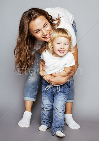 young pretty stylish mother with little cute blond daughter hugging, happy smiling real family, life Stock photo © iordani