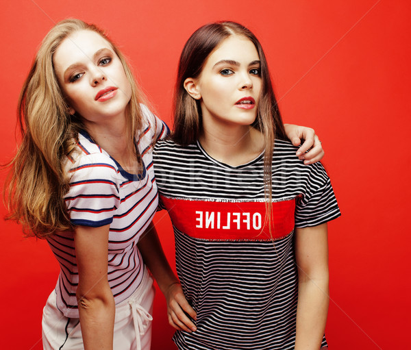 Stock photo: two best friends teenage girls together having fun, posing emotional on red background, besties happ