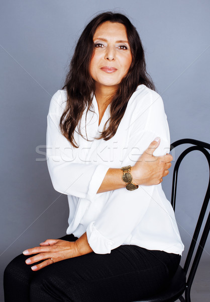 Destul de bruneta femeie matura şedinţei scaun studio Imagine de stoc © iordani