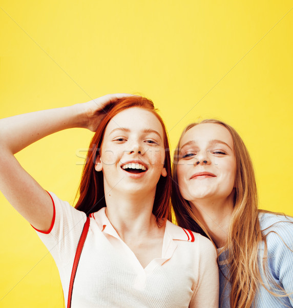 lifestyle people concept: two pretty young school teenage girls having fun happy smiling on yellow b Stock photo © iordani
