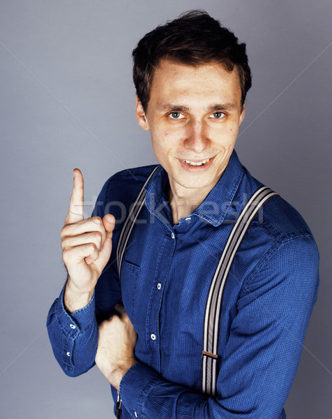 young goofy man with pimples pointing in studio Stock photo © iordani
