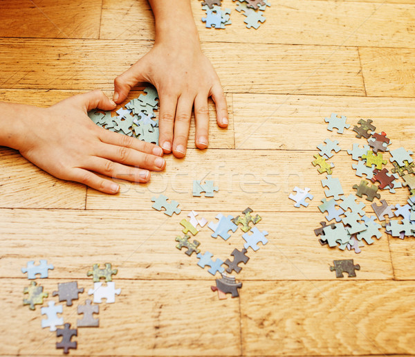 little kid playing with puzzles on wooden floor together with pa Stock photo © iordani