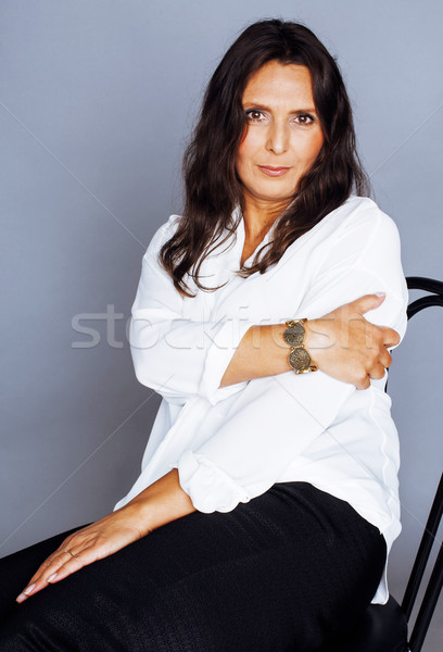 pretty brunette confident mature woman sitting on chair in studi Stock photo © iordani