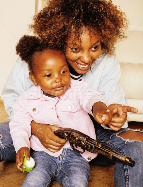 adorable sweet young afro-american mother with cute little daughter, hanging at home, having fun pla Stock photo © iordani