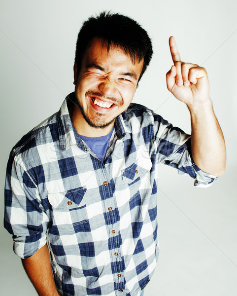 young cute asian man on white background gesturing emotional, pointing, smiling, lifestyle people co Stock photo © iordani