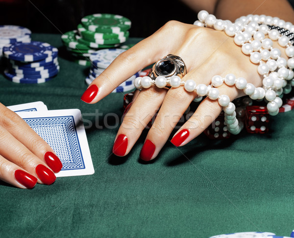 hands of young caucasian woman with red manicure at casino table Stock photo © iordani