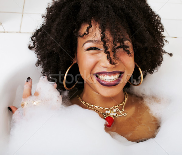 young afro-american girl in a black bikini sitting in bath, wear Stock photo © iordani