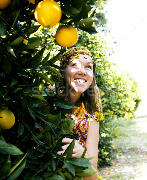 pretty woman in orange grove smiling Stock photo © iordani