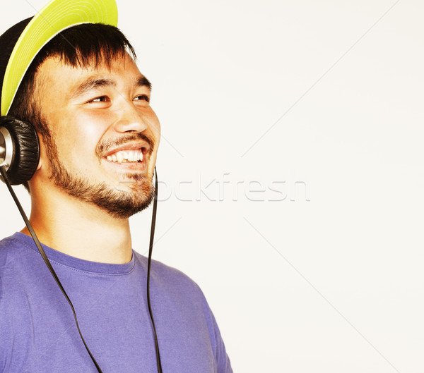young asian man in hat and headphones listening music on white b Stock photo © iordani