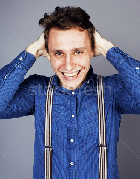 young goofy man with pimples pointing in studio Stock photo © iordani