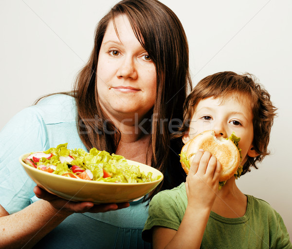 mature woman holding salad and little cute boy with hamburger te Stock photo © iordani