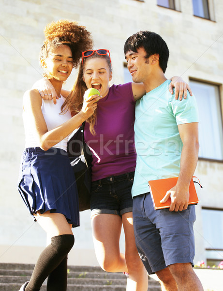 cute group of teenages at the building of university with books huggings, back to school Stock photo © iordani