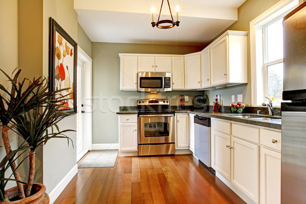 Stock photo: Elegant white and green kitchen with cherry floor.