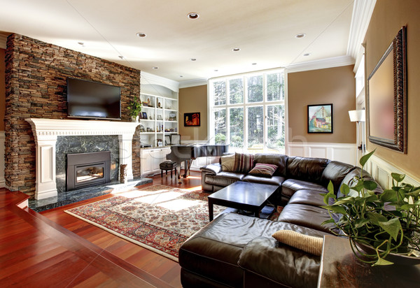 Stock photo: Luxury living room with stobe fireplace and leather sofas.