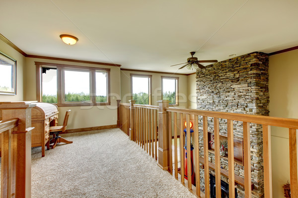 Stock photo: House hallway with stone fireplace and wood railing.