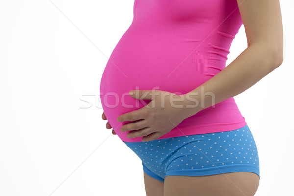 Pregnant woman holding belly in pink and blue. Stock photo © iriana88w