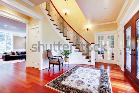 Entrance with curved staircase and luxury rug with chair. Stock photo © iriana88w