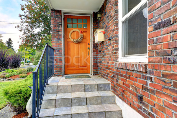 House with brick trim. Entrance porch with orange door Stock photo © iriana88w