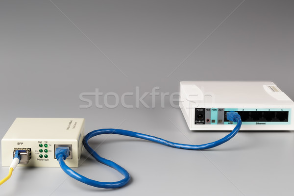 Media converter with optical patchcord and router connected via copper cable Stock photo © ironstealth