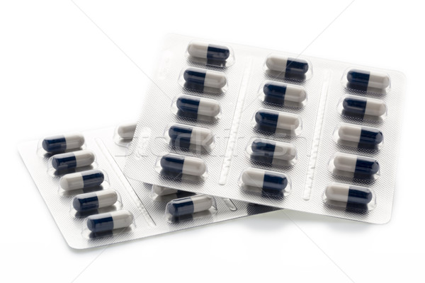 Stock photo: Dark blue and white capsules in medication blister packs.