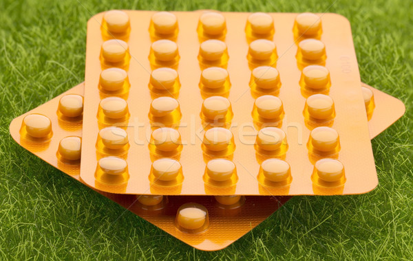 Set of orange pill blister pack on grass background Stock photo © ironstealth
