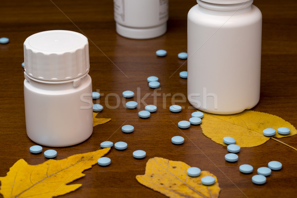 Stock photo: Blue pills and medicine bottle on wooden background