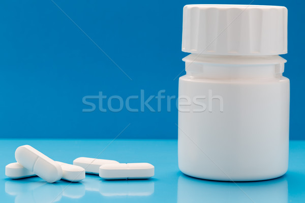 White pills and plastic pill bottle Stock photo © ironstealth