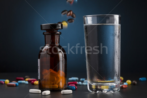 Medicine bottle pills colorful and glass of drink water Stock photo © ironstealth