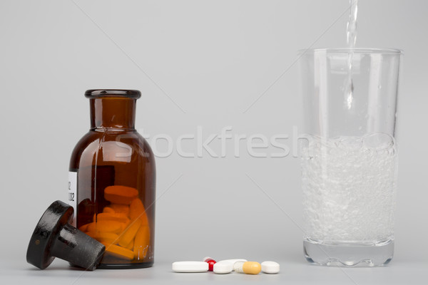 Stock photo: Various pills,medical bottle and glass of fizzy water