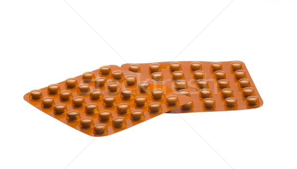 Medicine orange pills packed in blisters isolated on white background Stock photo © ironstealth