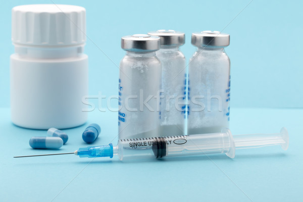 Healthcare and medicine concept.Syringe,pills bottle on blue background Stock photo © ironstealth