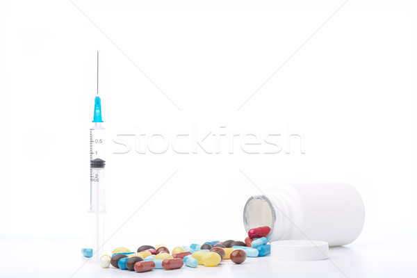 Syringe, plastic bottle and pills on white background Stock photo © ironstealth