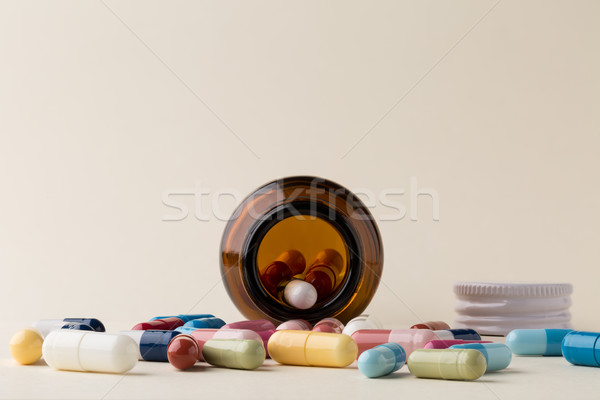 Bottle of pills from the brown glass and colorful capsules Stock photo © ironstealth