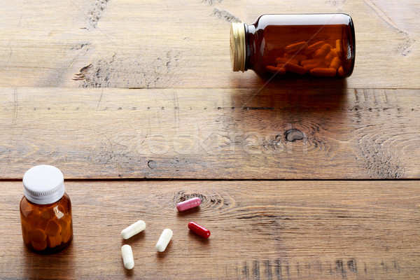 Medical bottles with white pills on a wooden background Stock photo © ironstealth