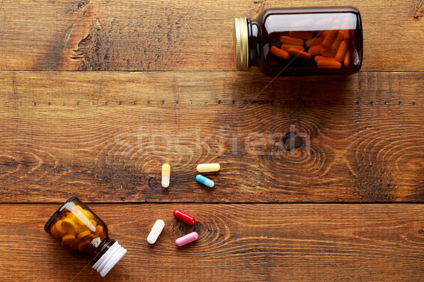 Medical bottles with white pills on a wooden background Stock photo © ironstealth