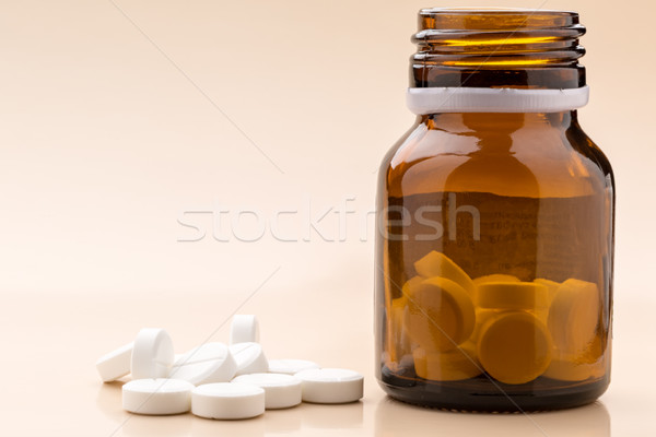 Round white pills and glass pill bottle Stock photo © ironstealth