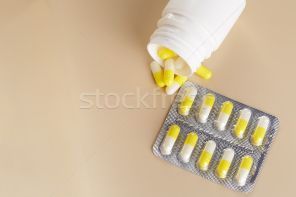 Yellow medicine capsules. Pills blister pack and tablets bottle Stock photo © ironstealth