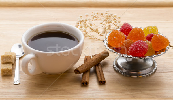 Fresh cup of hot tea, colorful marmalade, brown sugar cane cubes and cinnamon sticks. Stock photo © ironstealth