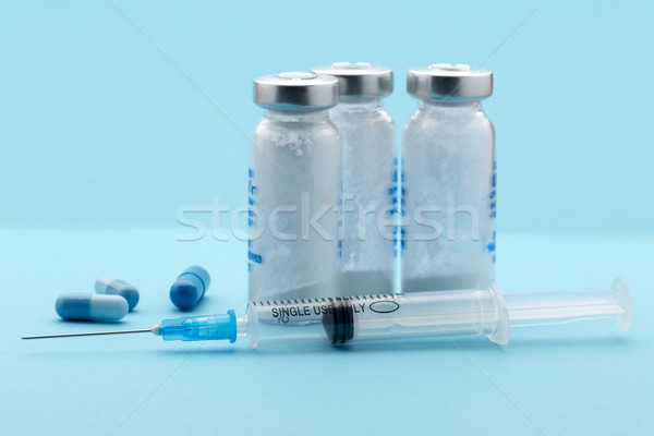Healthcare and medicine,syringe, pills, medicine bottle on blue background Stock photo © ironstealth