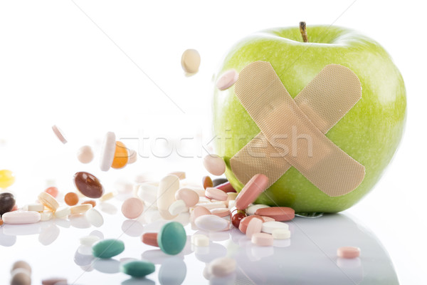 Green apple with a band-aid and varios pills Stock photo © ironstealth