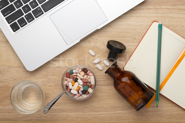 On-line treatment concept with bottles of medicine pills on the table Stock photo © ironstealth
