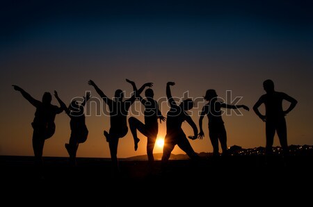 Szczęśliwy młodych ludzi grupy sylwetki taniec plaży Zdjęcia stock © IvicaNS