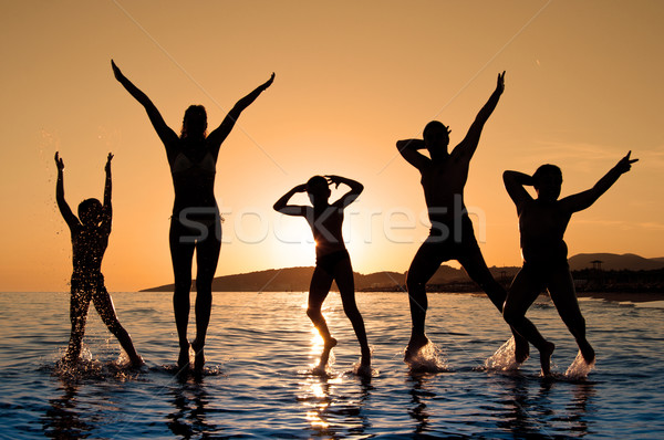 Sylwetka rodziny skoki plaży piękna lata Zdjęcia stock © IvicaNS