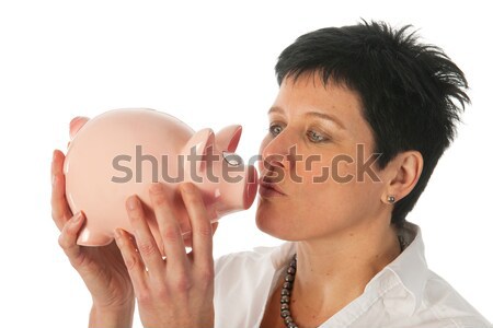 Stock photo: Young woman kissing piggy bank