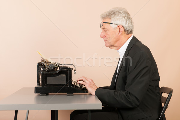 Senior homem antigo máquina de escrever escrita preto Foto stock © ivonnewierink