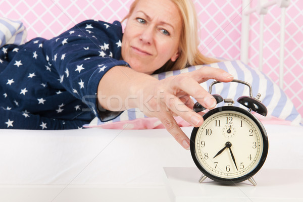 Woman put out the alarm clock Stock photo © ivonnewierink
