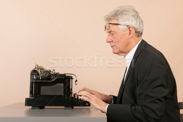 Stock photo: Senior man with antique typewriter